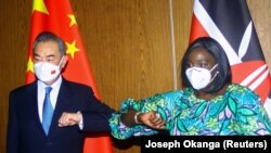 FILE: While Kenya traders protest Chinese competition, Chinese Foreign Minister Wang Yi and his Kenyan counterpart Raychelle Omamo bumped elbows during a news conference in the coastal city of Mombasa, Kenya. Taken Jan. 6, 2022