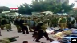 Image taken from amateur video shows soldiers moving among prone men in civilian clothes, whose hands are apparently tied behind their backs, at a location given as Daraa
