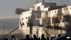 Italian firemen work outside the Norman Atlantic ferry after that has been towed into the port of Brindisi, southern Italy, Jan. 2, 2015.