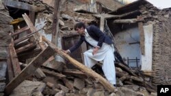 Warga Pakistan memeriksa rumahnya yang hancur akibat gempa bumi di Mingora, kota utama di lembah Swat (27/10). (AP/Naveed Ali)