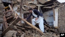 A Pakistani youth examines an earthquake-damaged house in Mingora, the main town of Swat valley, Oct. 27, 2015.