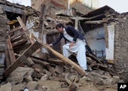 A Pakistani boy examines an earthquake-damaged house in Mingora, the main town of Swat valley, Oct. 27, 2015.