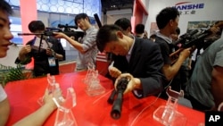 FILE - Visitors try out modern weapons during an exhibition of police equipment and anti-terror technologies held in Beijing.