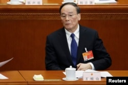 FILE - China's Politburo Standing Committee member Wang Qishan attends the opening of the annual full session of the National People's Congress (NPC), the country's parliament, at Great Hall of the People.