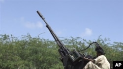 A Somali government soldier on a truck manning an anti aircraft gun takes up position during clashes with Islamist insurgents in southern Mogadishu's Hodon neighborhood , Somalia, 3 Oct 2010