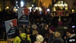 Những người biểu tình cầm ảnh của Tổng thống Donald Trump phản đối việc ông dự Diễn đàn Kinh tế Thế giới tại Davos ở Thụy Sĩ ngày 23/1/2018. 