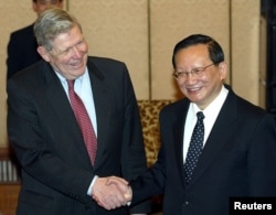 FILE - U.S. Assistant Secretary of State James Kelly (left) shakes hands with Chinese State Councillor and former foreign minister Tang Jiaxuan in Beijing Feb. 26, 2004.