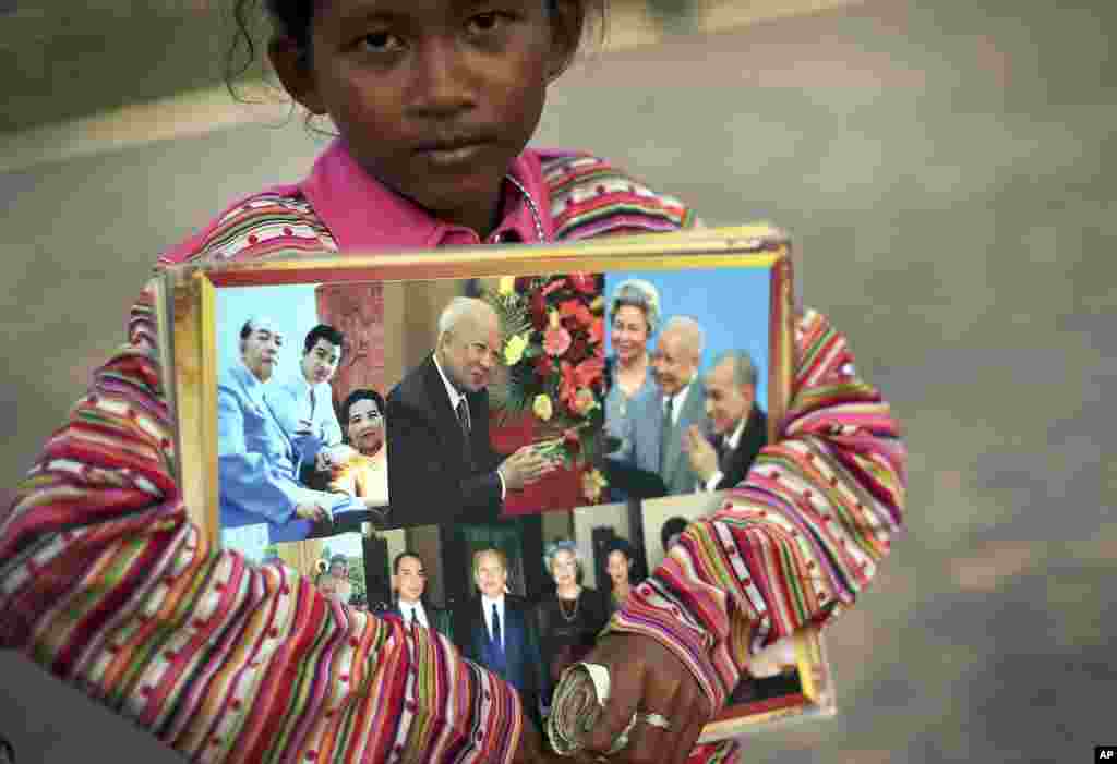 A young girl sells photos of the late Cambodian King Norodom Sihanouk ahead of his funeral, Thursday, Jan. 31, 2013, in Phnom Penh, Cambodia. The body of Sihanouk who died on Oct. 15, 2012 at age 89, is scheduled to be cremated on Feb. 4, 2013. (AP Photo/Wong Maye-E)