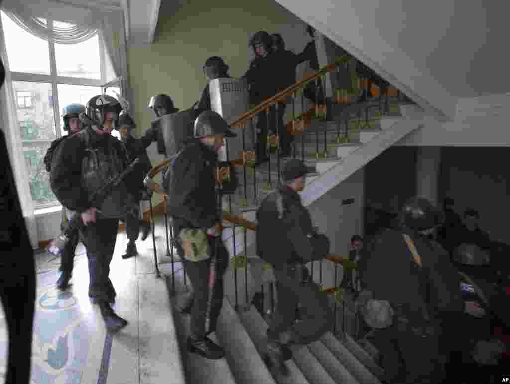 A group of Ukrainian police officers leave the administration building which has been captured by Pro-Russian activists in the center of Luhansk, Ukraine, one of the largest cities in Ukraine's troubled east, April 29, 2014.