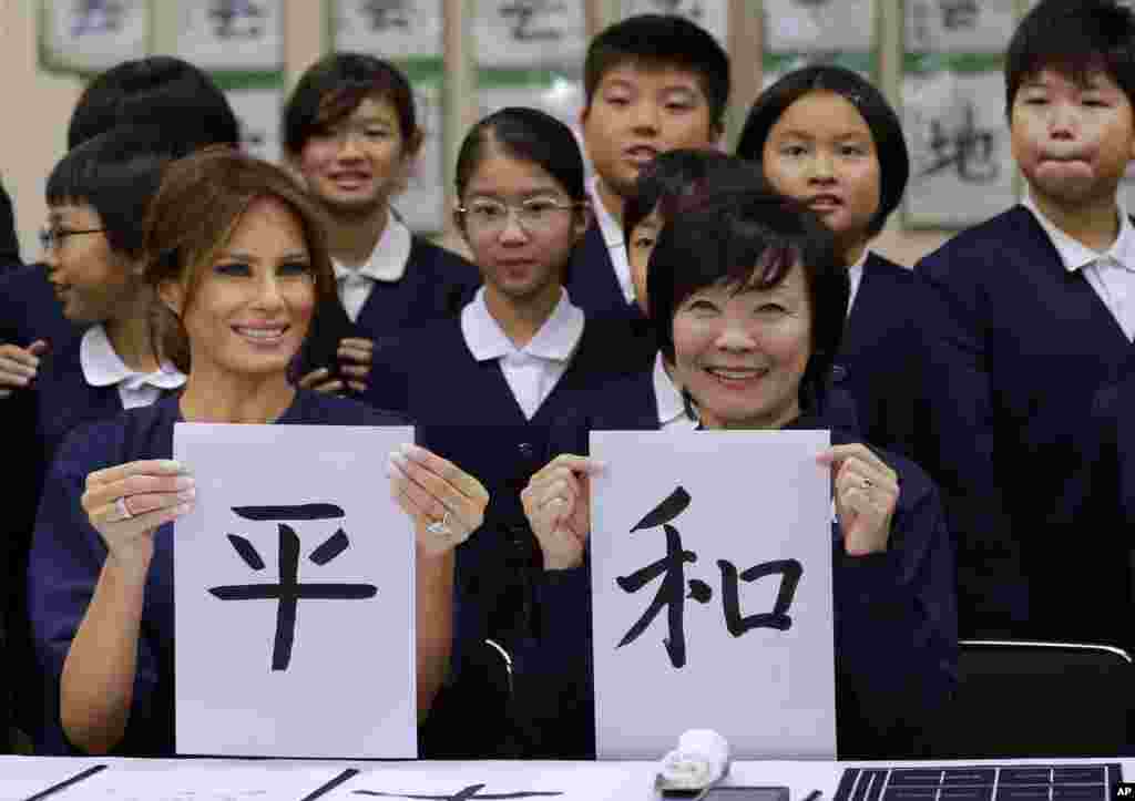 U.S. first lady Melania Trump, left, and Japanese Prime Minister Shinzo Abe&#39;s wife Akie show off calligraphy they wrote as they attend a calligraphy class of the 4th grader at Kyobashi Tsukiji Elementary School in Tokyo, Nov. 6, 2017.