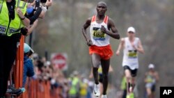 Geoffrey Kirui of Kenya leads Galen Rupp of the United States and the rest of the field along the course of the 121st Boston Marathon in Brookline, Massachusetts, April 17, 2017.