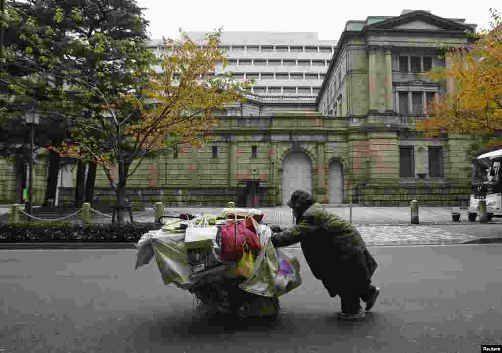 جاپان میں ایک بے گھر شخص ٹرالی میں لدے اپنے سامان کو آگے کی طرف دھکیل رہا ہے۔