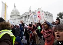 FILE - Demonstrators march during an immigration rally in support of the Deferred Action for Childhood Arrivals (DACA), on Capitol Hill in Washington, Dec. 6, 2017.