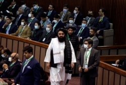 Taliban acting foreign minister Amir Khan Muttaqi, center, arrives for the extraordinary session of Organization of Islamic Cooperation (OIC) Council of Foreign Ministers, in Islamabad, Dec. 19, 2021.