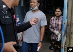 FILE - Burmese workers Tin Nyo Win, left, and Mi San smile upon being reunited in Samut Sakhon, Thailand, Nov. 9, 2015. They were separated while trying to escape the shrimp shed where they were held as slaves.