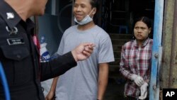 Tin Nyo Win, left, smiles upon being reunited with his wife, Mi San, in Samut Sakhon, Thailand, Nov. 9, 2015. They were separated while fleeing a shrimp shed where they were held as slaves. Tin, labeled No. 31, sought help from a labor rights group.