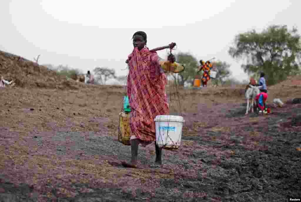 A woman carries water from a water hole near Jamam refugee camp in South Sudan's Upper Nile State, March 10, 2012.