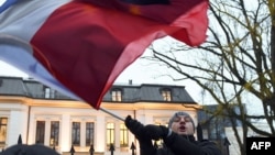 FILE - A protester waves the flags of Poland and the European Union in front of the Polish Constitutional Court in Warsaw on Dec. 3, 2015. The Polish parliament's lower house on Sept. 13, 2024, approved legislation to reform the court.