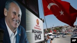 A supporter of Muharrem Ince, pictured left, the presidential candidate of Turkey's main opposition Republican People's Party, waves a Turkish flag prior to one of his rallies, in Istanbul, Turkey, June 16, 2018.