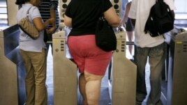 FILE: An overweight woman walks through a turnstyle. Half of Americans will be obese by 2030, says a new study.