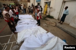 FILE - The bodies of people killed by an airstrike on a fish market are laid out in plastic bags at a hospital in Hodeida, Yemen, Aug. 2, 2018.