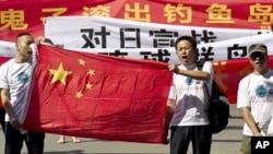 Chinese protesters hold banners reading "Declare war against Japan" and "Japan get out of Diaoyu islands" during a protest outside the Japanese Embassy in Beijing Aug. 15, 2012. 