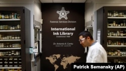 In this June 27, 2019 photo, document analysis technician Irvin Rivera carries an ink sample in the U.S. Secret Service's International Ink Library in Washington.