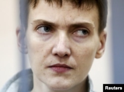 FILE - Ukrainian military pilot Nadiya Savchenko looks out from a defendants' cage during a court hearing in Moscow, Russia, May 6, 2015.