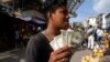 Un joven muestra sus billetes de un dólar en un mercado callejero en Caracas, Venezuela, el 11 de junio de 2021.