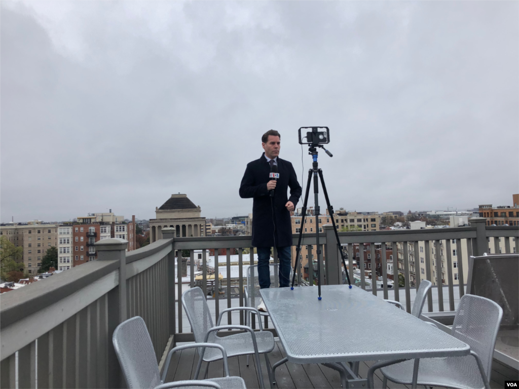 VOA Latin America journalist reports from a rooftop studio.