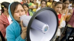 A Cambodian garment worker speaks on a loud speaker as she leads a strike in front of a factory on the outskirts of Phnom Penh, file photo. 