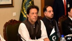 FILE - In this photo released by the Press Information Department, Pakistani Prime Minister Imran Khan, center, attends a briefing at the Foreign Ministry in Islamabad, Pakistan, Aug. 24, 2018. 