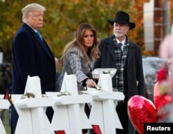 FILE - U.S. President Donald Trump and first lady Melania Trump stand with Rabbi Jeffrey Myers as they place stones at a makeshift memorial outside the Tree of Life synagogue in Pittsburgh, Oct. 30, 2018.