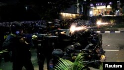 Anggota Brimob menggunakan senjata saat terjadi bentrokan dengan demonstran di Jakarta, Rabu dini hari (22/5) di Jakarta. (Foto: Willy Kurniawan/Reuters).