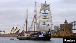 A supplied photo shows a tall ship displaying banners as it sails on Sydney Harbor in Australia, Sept. 8, 2018 as part of global climate change protests across 95 countries organized by the New York-based lobby group 350.org. 