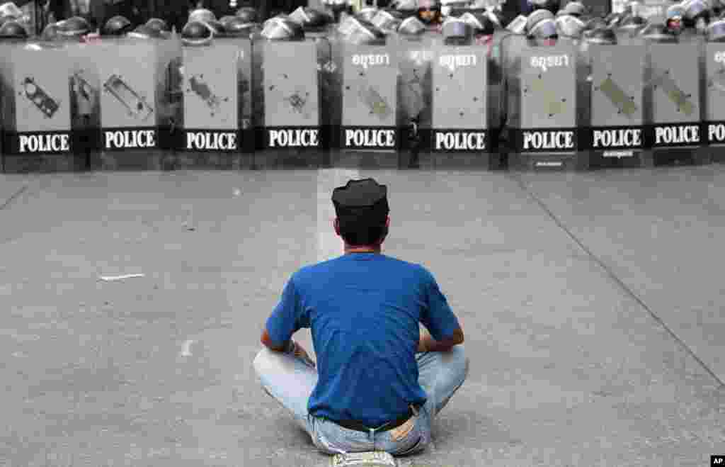 Seorang pria mengkonfrontasi polisi dalam operasi pengambilalihan kantor-kantor pemerintah yang diduduki para demonstran anti-pemerintah di pinggiran kota Bangkok (14/2).&nbsp;(AP/Wason Wanichakorn)