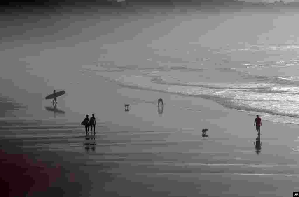 People walk on the beach of Biarritz, southwestern France, along the Atlantic Ocean. Temperatures in southwestern France rose an unusual 20 degrees Celsius (68 degrees Fahrenheit).