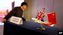 FILE - Staff workers prepare for a signing ceremony by British officials with China's Hainan Airlines Group to develop new flight routes to encourage Chinese tourists to Britain in Beijing, China, May 18, 2016.