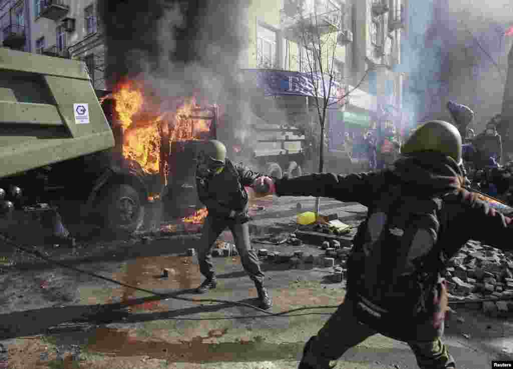 Anti-government protesters throw stones towards Interior Ministry officers during a rally, near Parliament, in Kyiv, Feb. 18, 2014.