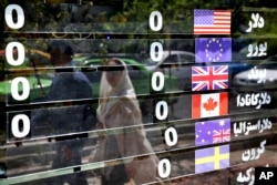 Various currencies are displayed without the going rate on a money exchange shop window in downtown Tehran, Iran, Aug. 7, 2018.