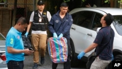 Полиция Таиланда выносит вещественные доказательства из квартиры подозреваемого в пригороде Бангкока. Таиланд. 29 августа 2015 г. 