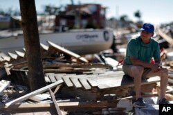 Hector Morales sits on a debris pile near his home which was destroyed by Hurricane Michael, in Mexico Beach, Florida, Oct. 12, 2018. "I have nothing else to do. I'm just waiting," said Morales as he wonders what he will do next. "I lost everything."