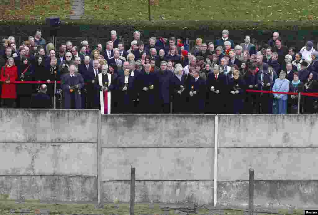 German Chancellor Angela Merkel (6th R) and dignitaries take part in a ceremony marking the 25th anniversary of the fall of the Berlin Wall at a memorial in Bernauer Strasse in Berlin, Nov. 9, 2014. 
