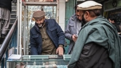 An Afghan man looks at the currency notes on display at a money exchange shop in Kabul on Dec. 20, 2021.