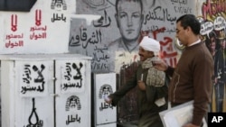 Egipcios pasan junto a un grafiti en la plaza Tahrir en El Cairo en el que se lee: “no a la Constitución de la Hermandad Musulmana”.