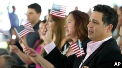 Tân công dân cầm cờ Mỹ trong buổi lễ tuyên thệ nhập quốc tịch ở trường đại học quốc tế Florida ngày 6/7/2015.