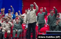 FILE - Venezuela's President Nicolas Maduro leads the seventh anniversary celebration of the Bolivarian Militia, in front of the Miraflores presidential palace in Caracas, Venezuela, April 17, 2017.