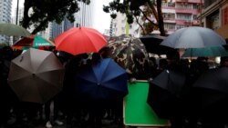 Manifestantes en Hong Kong se ocultan detrás de sombrillas durante una marcha de Año Nuevo el 1 de enero de 2020.