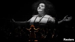 Clown performer Gabriela Munoz stands in front of the GIO Symphonia orchestra during a preview of "The Silence of Sound" in Girona, Spain on November 25, 2021, in this handout photo obtained by Reuters on December 01, 2021. 