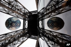 American street artist Shepard Fairey's (aka Obey) latest piece 'Earth Crisis,' a giant sphere themed on environment and hanging between the first and second floor of the Eiffel Tower in Paris, Nov. 20, 2015.